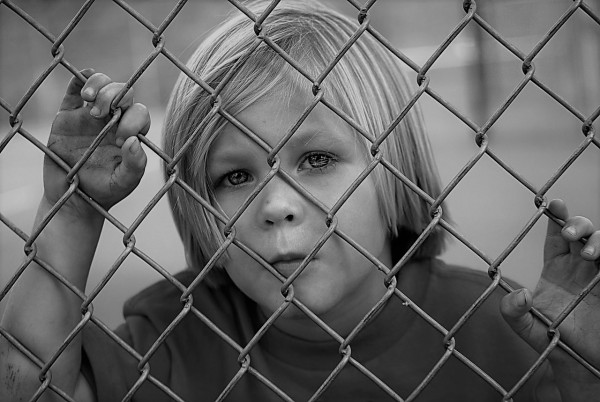 young boy chain fence